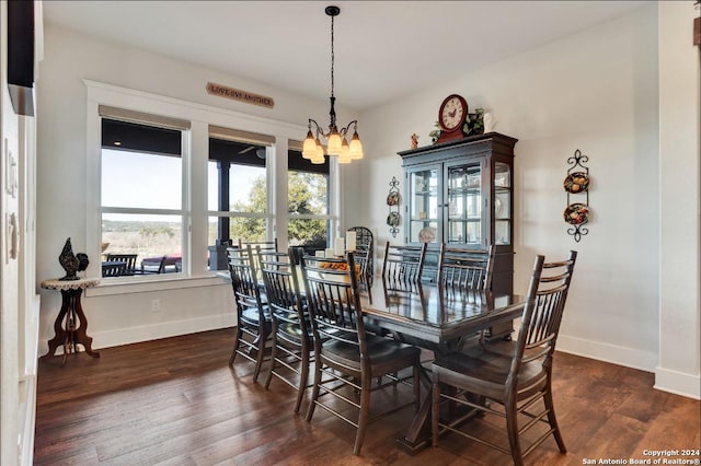 dining room with dark hardwood / wood-style flooring and a chandelier