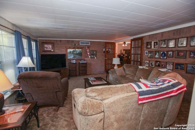 living room featuring wood walls, carpet floors, and ornamental molding