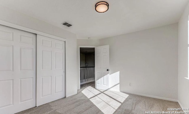 unfurnished bedroom featuring carpet flooring and a closet