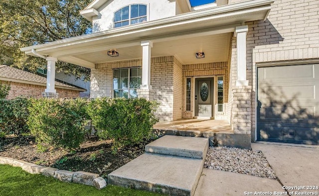 view of exterior entry with a porch and a garage