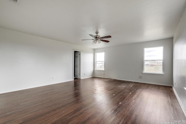 unfurnished room with ceiling fan and dark wood-type flooring