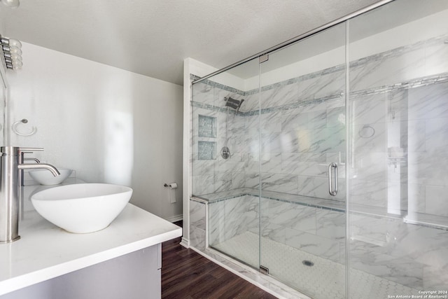 bathroom with hardwood / wood-style floors, vanity, a textured ceiling, and walk in shower