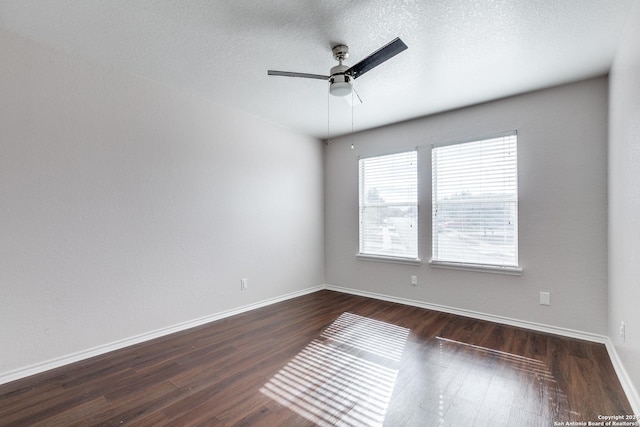 spare room with a textured ceiling, ceiling fan, and dark wood-type flooring