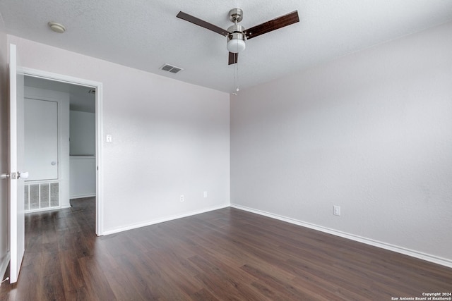 spare room featuring ceiling fan, dark wood-type flooring, and a textured ceiling