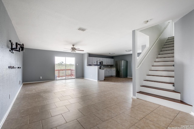 unfurnished living room featuring ceiling fan and light tile patterned floors