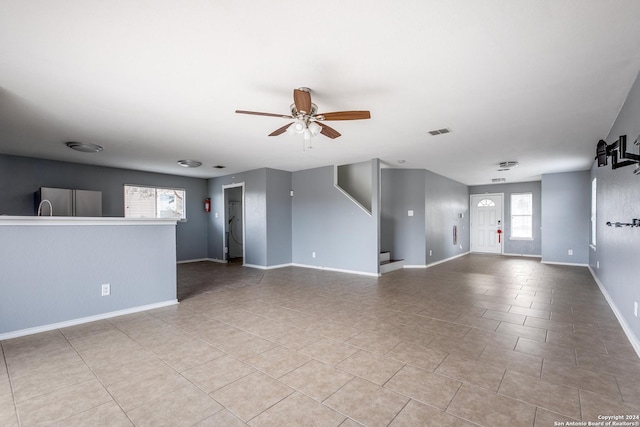 tiled spare room with ceiling fan and a wealth of natural light