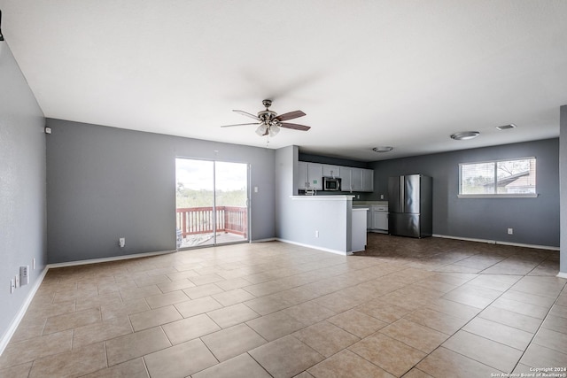 unfurnished living room featuring ceiling fan and light tile patterned floors