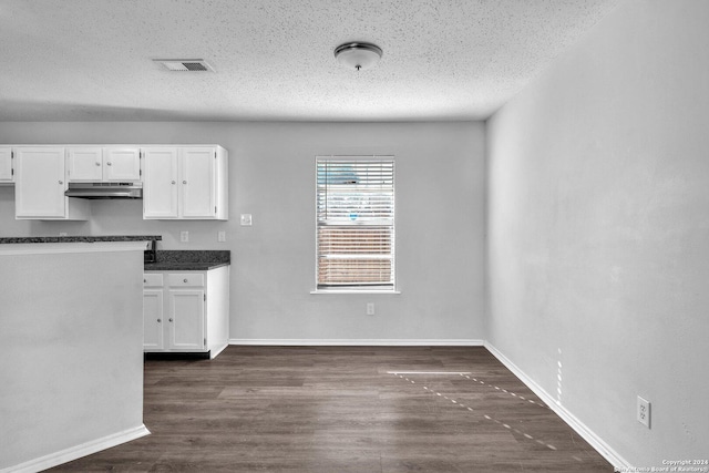 kitchen with white cabinets, a textured ceiling, and dark hardwood / wood-style flooring