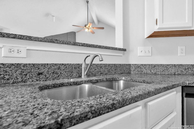 kitchen featuring dark stone counters, ceiling fan, sink, white cabinets, and lofted ceiling