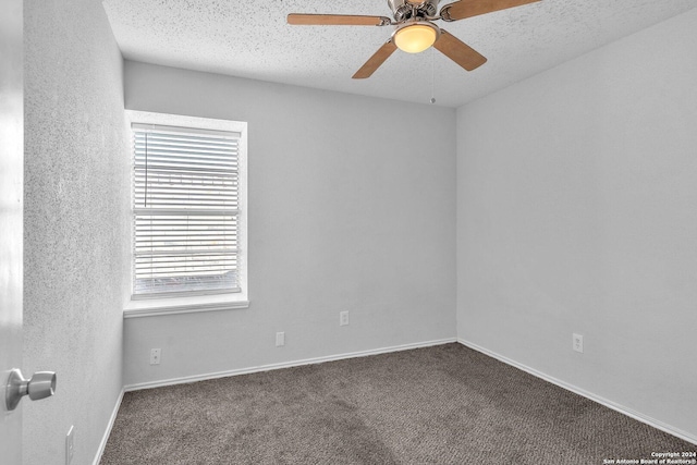 unfurnished room with a wealth of natural light, dark carpet, and a textured ceiling