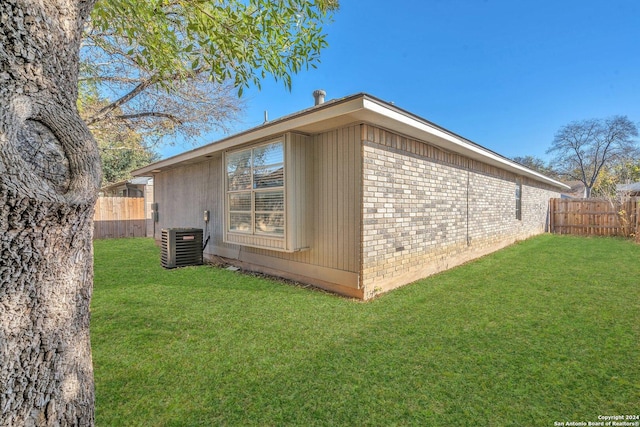 view of side of property featuring a yard and cooling unit