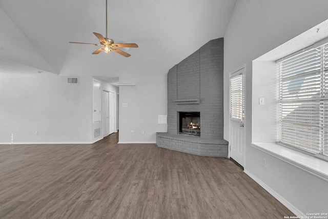 unfurnished living room with hardwood / wood-style floors, ceiling fan, a fireplace, and vaulted ceiling