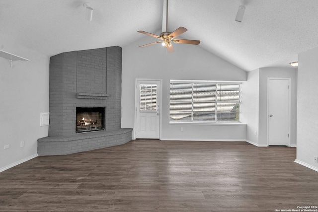 unfurnished living room with ceiling fan, dark hardwood / wood-style floors, lofted ceiling, and a fireplace