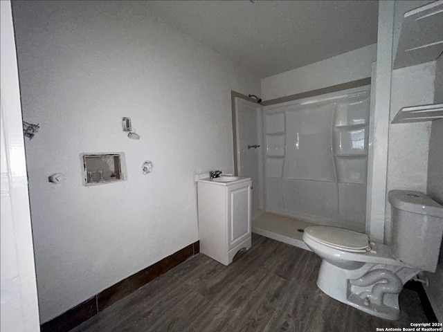 bathroom featuring a shower, sink, hardwood / wood-style flooring, and toilet