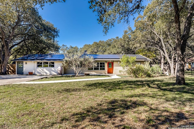 single story home featuring a front yard and solar panels