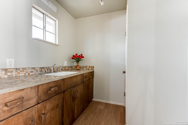 bathroom with hardwood / wood-style flooring, vanity, and backsplash