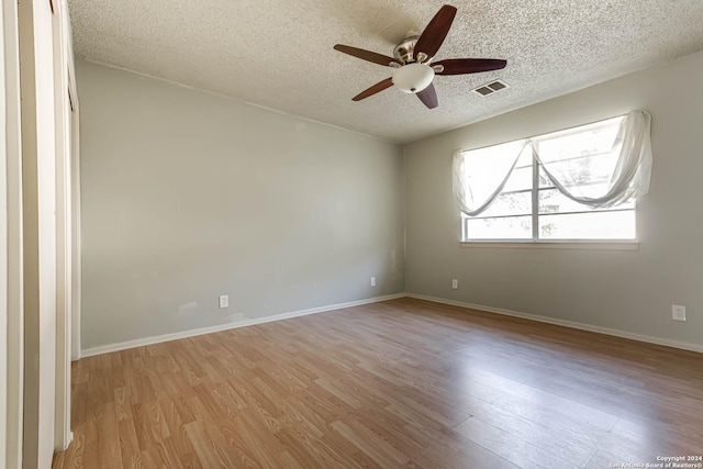 spare room featuring a textured ceiling, light hardwood / wood-style floors, and ceiling fan