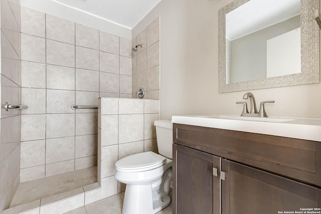 bathroom featuring tile patterned floors, vanity, toilet, and tiled shower