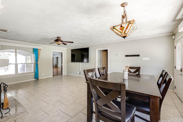 dining area featuring ceiling fan, crown molding, and light tile patterned flooring