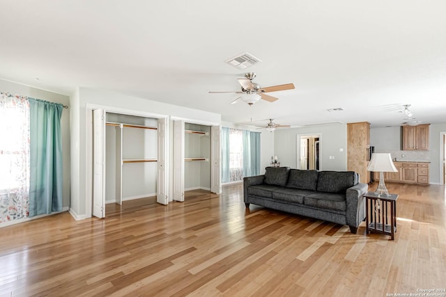 living room with ceiling fan and light hardwood / wood-style floors