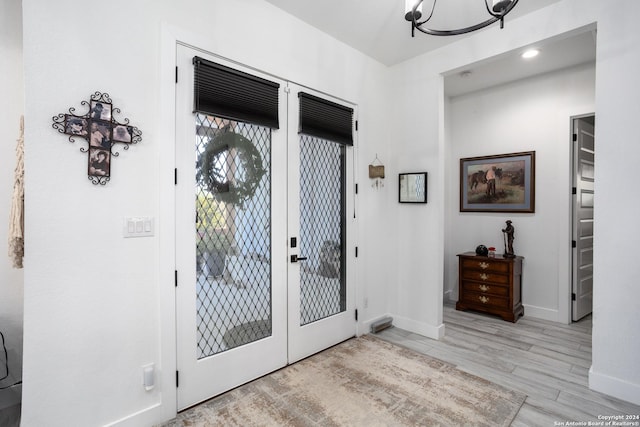 foyer entrance featuring a chandelier and light hardwood / wood-style flooring