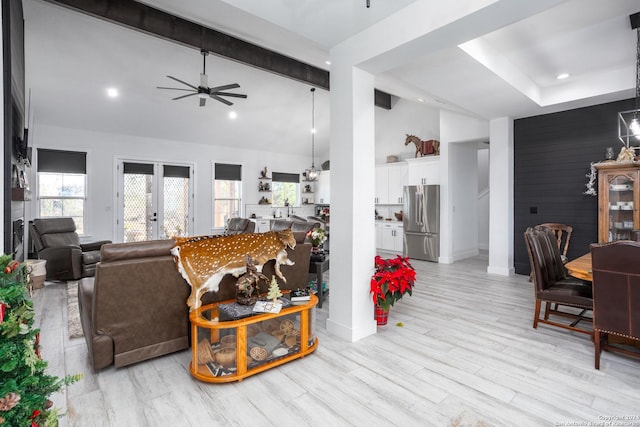 living room featuring lofted ceiling with beams, ceiling fan, french doors, and light hardwood / wood-style floors