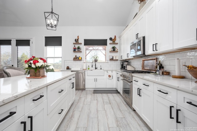 kitchen featuring white cabinets, pendant lighting, sink, and appliances with stainless steel finishes