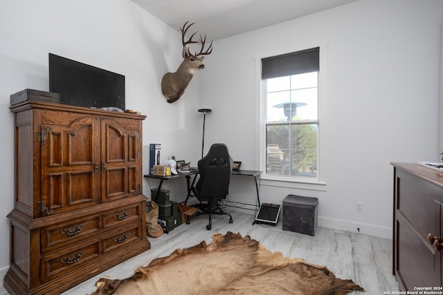 home office with light hardwood / wood-style floors