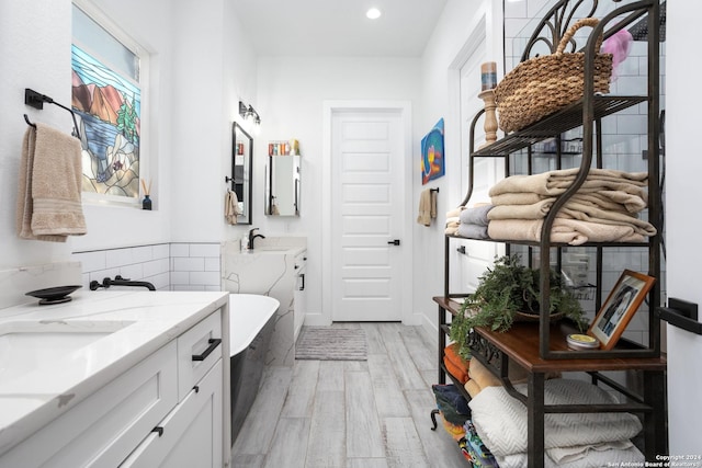 bathroom featuring a washtub, hardwood / wood-style floors, and vanity