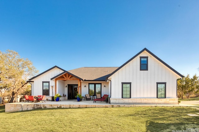 rear view of property with a lawn and a patio