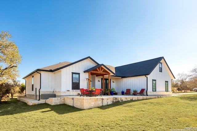 modern farmhouse with a front lawn and a patio