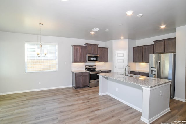 kitchen featuring light stone countertops, dark brown cabinets, stainless steel appliances, and sink