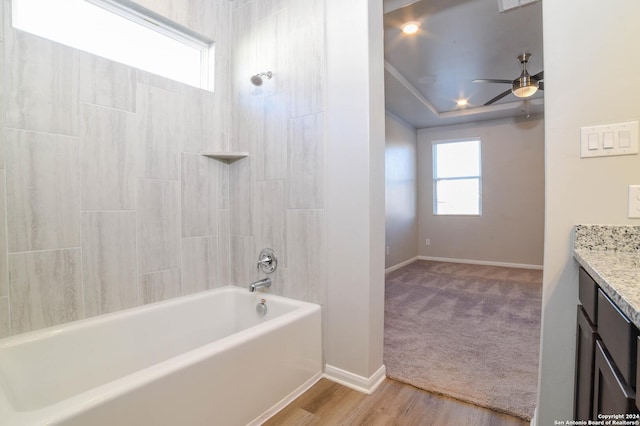 bathroom with hardwood / wood-style floors, vanity, ceiling fan, and  shower combination