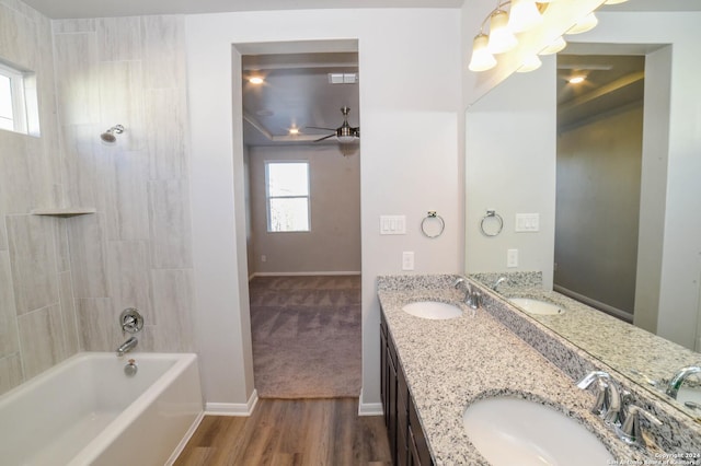 bathroom featuring hardwood / wood-style flooring, tiled shower / bath combo, ceiling fan, and vanity