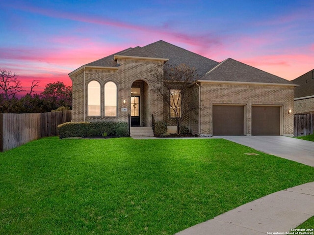 view of front of home featuring a garage and a lawn