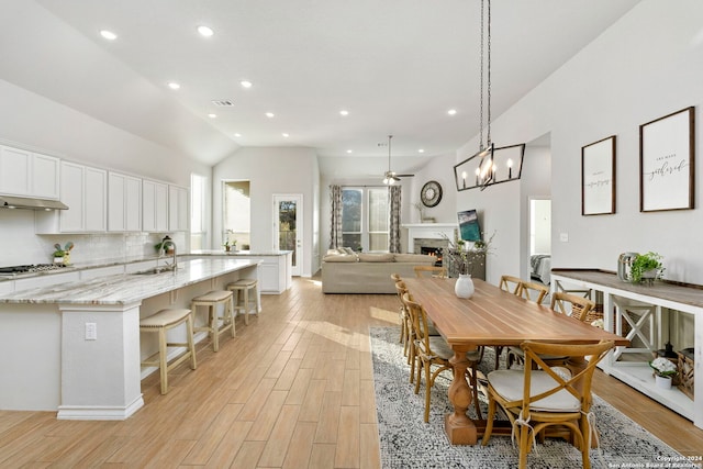 dining room featuring ceiling fan, lofted ceiling, and sink