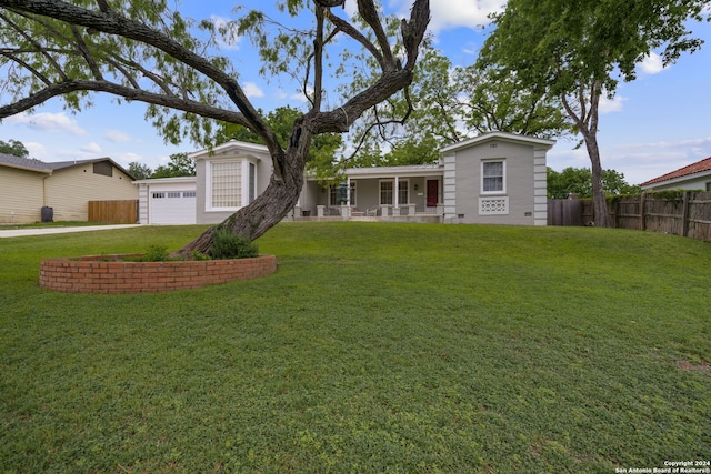 rear view of house featuring a yard, a porch, and a garage