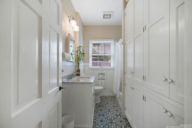 full bathroom featuring tile patterned flooring, vanity, shower / bath combo, and toilet