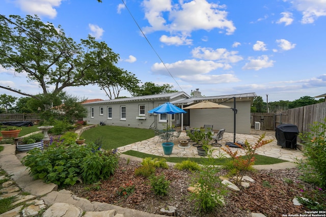 back of property with a lawn and a patio