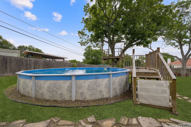 view of swimming pool featuring a deck and a yard