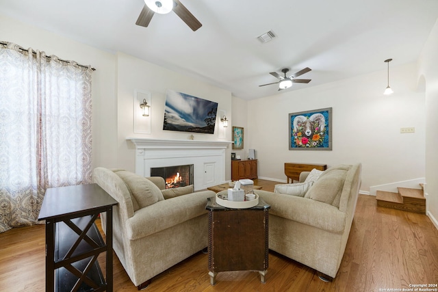 living room with light wood-type flooring and ceiling fan