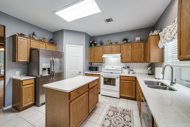 kitchen with decorative backsplash, sink, light tile patterned floors, and stainless steel appliances