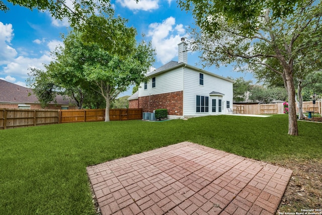 back of house with a lawn, central AC, and a patio