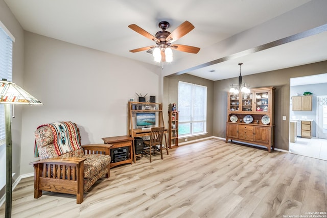 sitting room featuring ceiling fan with notable chandelier and light hardwood / wood-style flooring