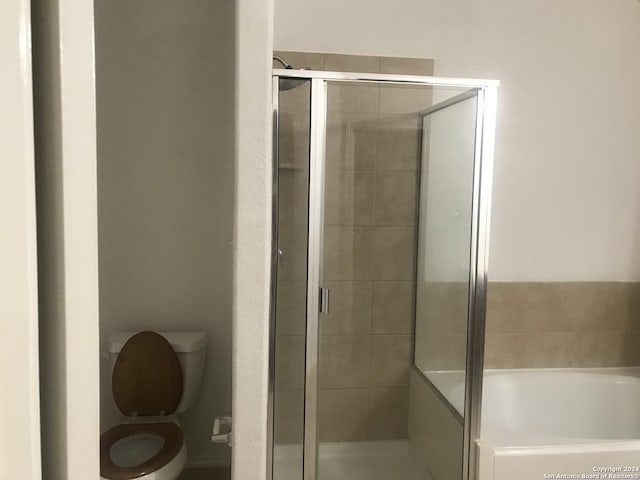 bathroom featuring plus walk in shower and toilet