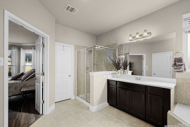 bathroom featuring tile patterned flooring, vanity, and a shower with shower door