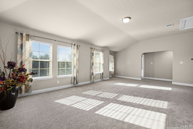 carpeted spare room featuring vaulted ceiling