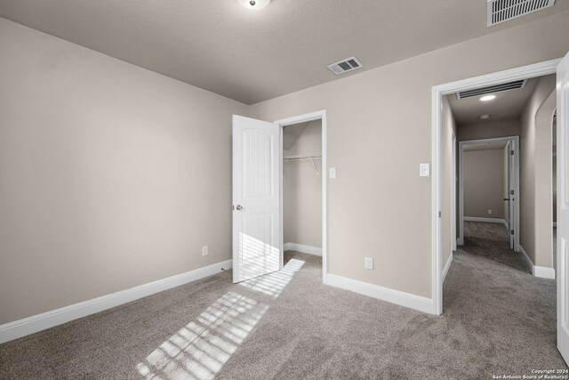 unfurnished bedroom with carpet flooring, a closet, and a textured ceiling