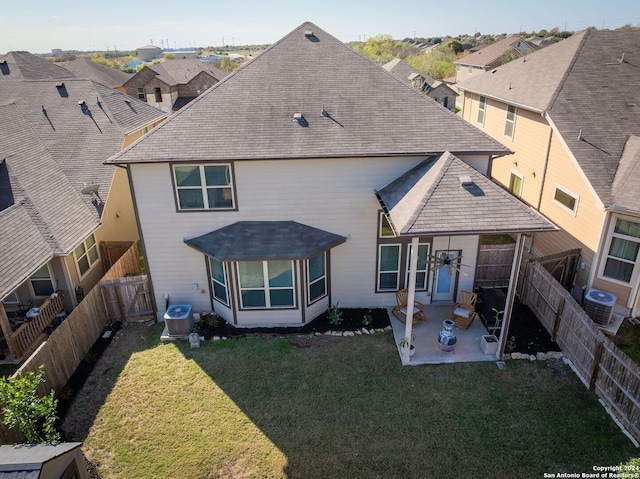 rear view of house with a yard, cooling unit, and a patio