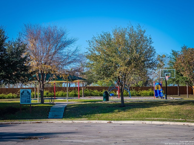 view of property's community featuring a lawn and basketball court